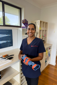 Gold Coast Hand Therapy OT, Vireshni Naidoo smiling, holding custom thermoplastic splint in clinic